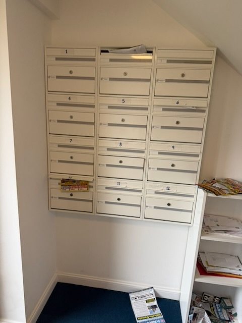 Bank of resident post boxes fitted with individual locks in a communal hallway